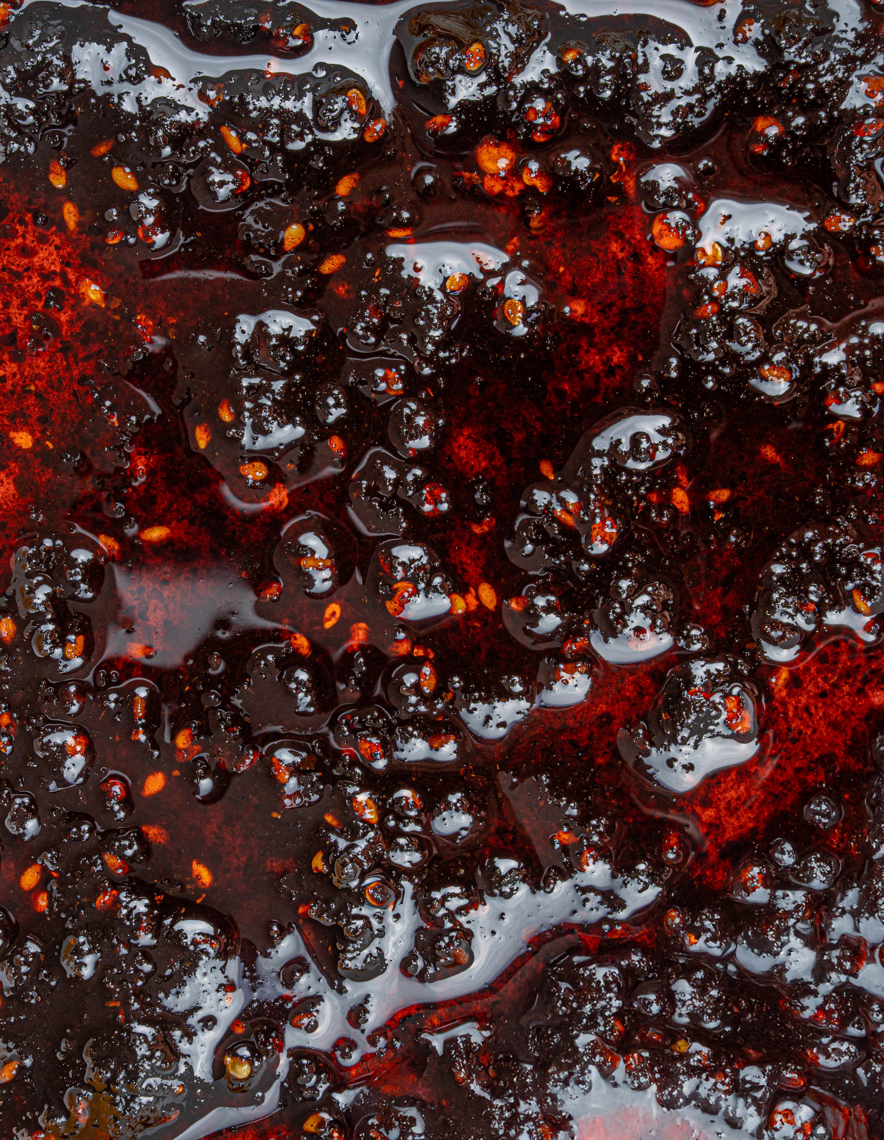 Macro shot of Salsa Macha chili oil showing rich red tones, sesame seeds, and crunchy texture