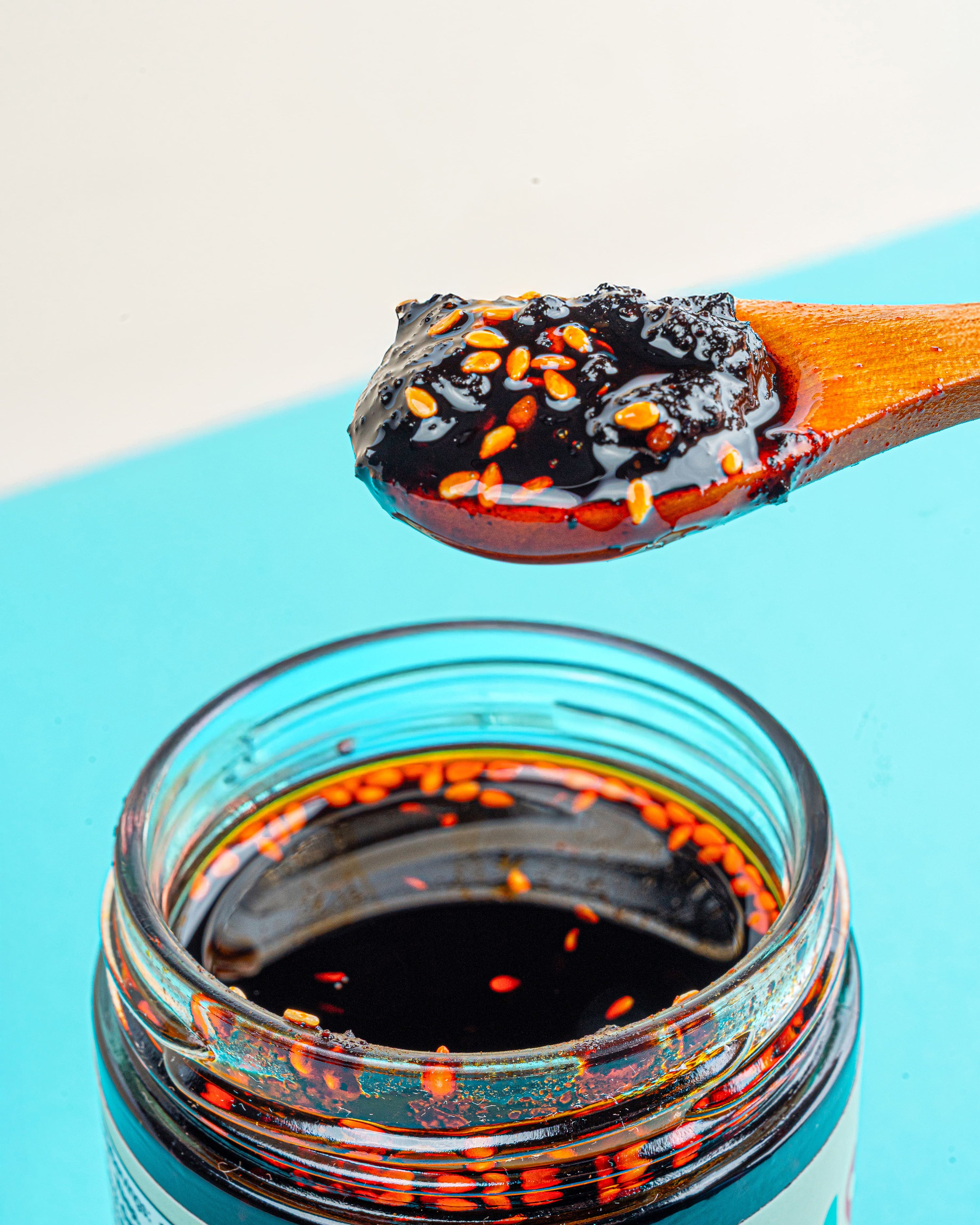 Close-up of a spoonful of Veracruz Salsa Macha showing its crunchy sesame seeds and chili oil texture